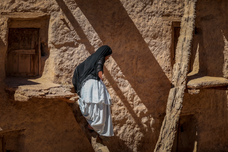 امرأة تمشي في مخزن الحبوب القديم في آيت كين