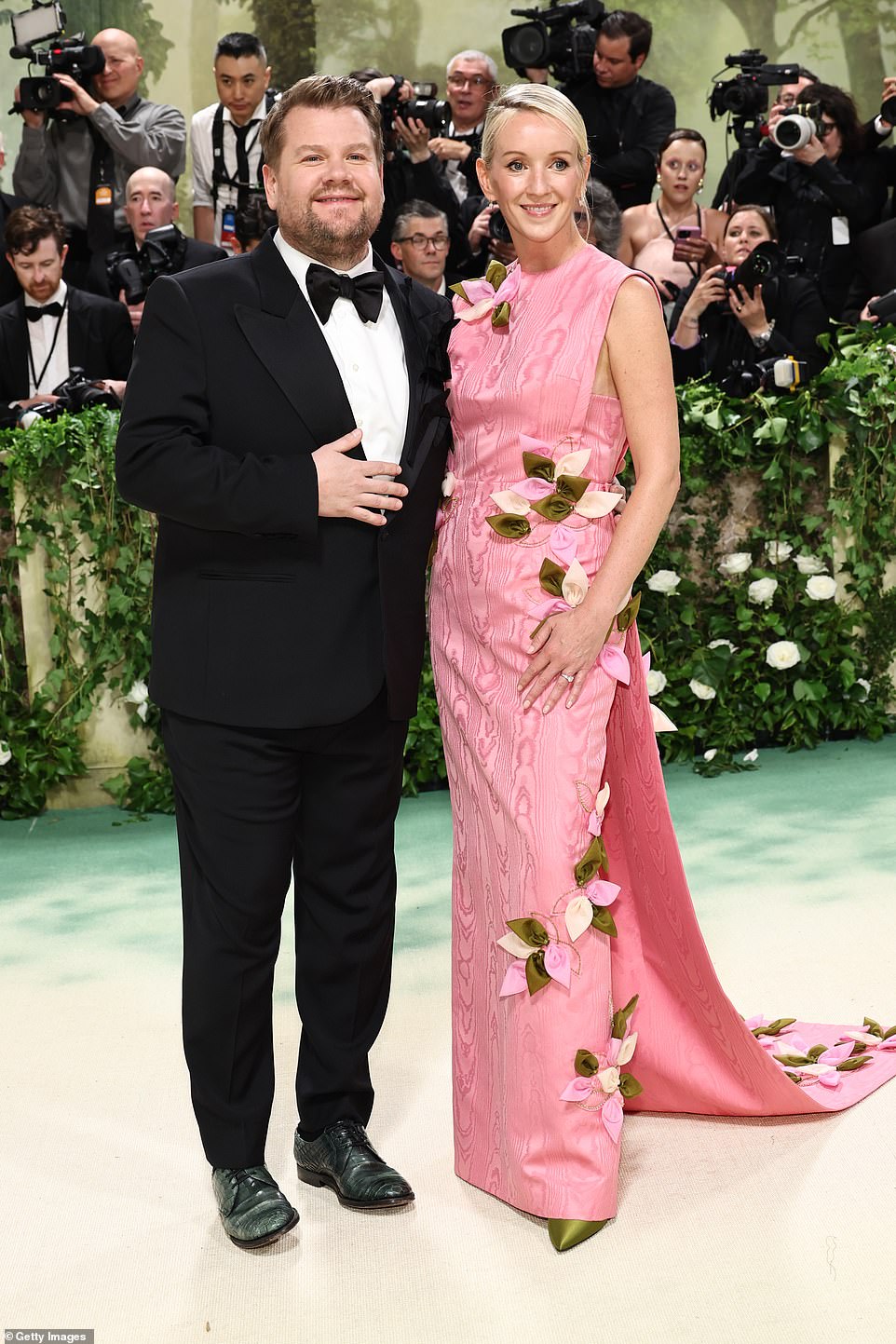 وبدا جيمس كوردن أنيقا ببدلة رسمية سوداء كلاسيكية بينما وقف بجانب زوجته جوليا كاري التي تألقت بفستان وردي بلا أكمام مزين بالورود.