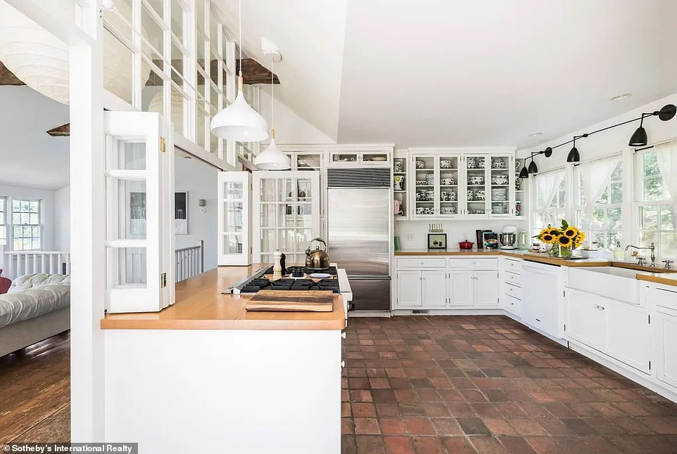 يتميز المطبخ بأرضيات مبلطة، وصف من النوافذ فوق الحوض يوفر إطلالات على أوراق الشجر في الخارج وزاوية إفطار مغطاة بالخشب.