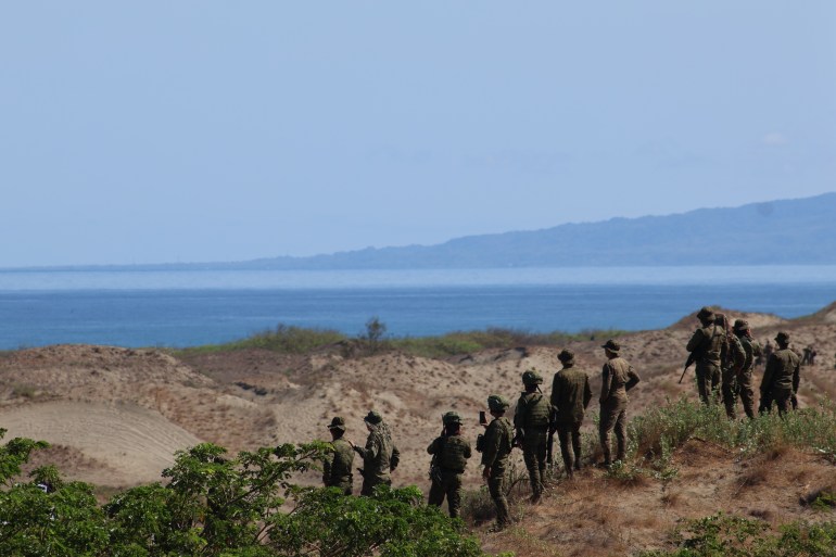 جنود يصطفون على الكثبان الرملية وينظرون إلى البحر.  ويمكن رؤية كتلة أرضية أخرى على مسافة